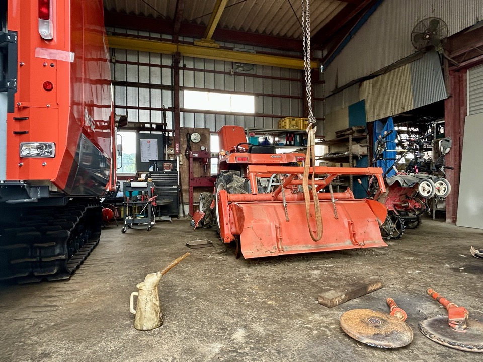 農機具屋の整備工場でコンバインを修理している様子
