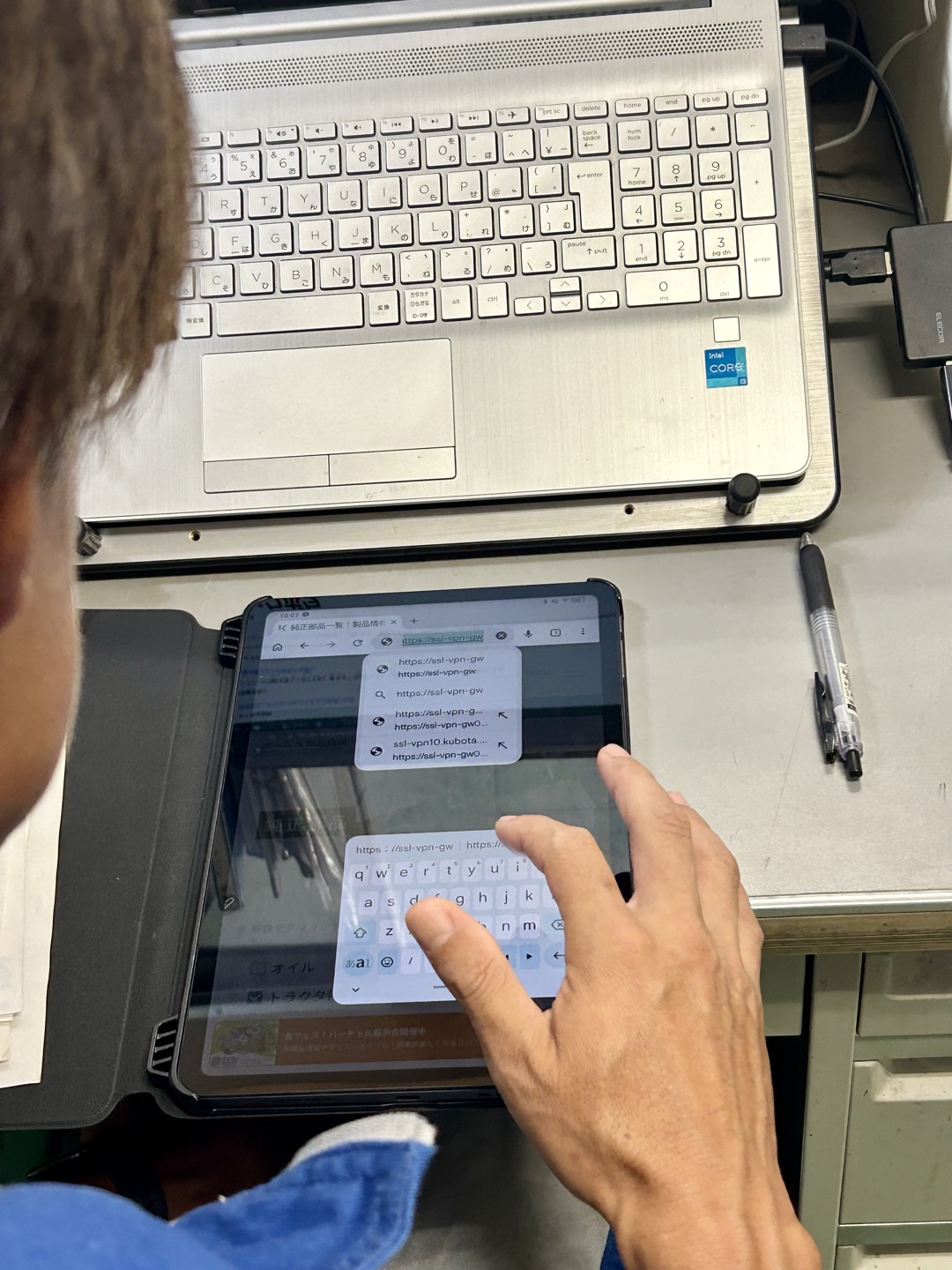 事務所でタブレットとパソコンを並べて作業している様子