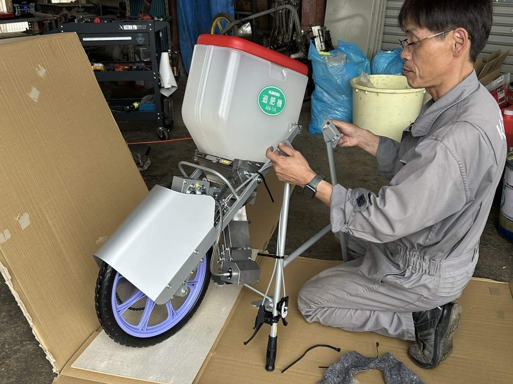 組み立て中の一輪タイプの肥料散布機