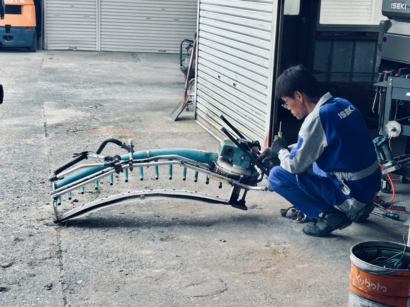 農機具を屋外で整備する整備士さん