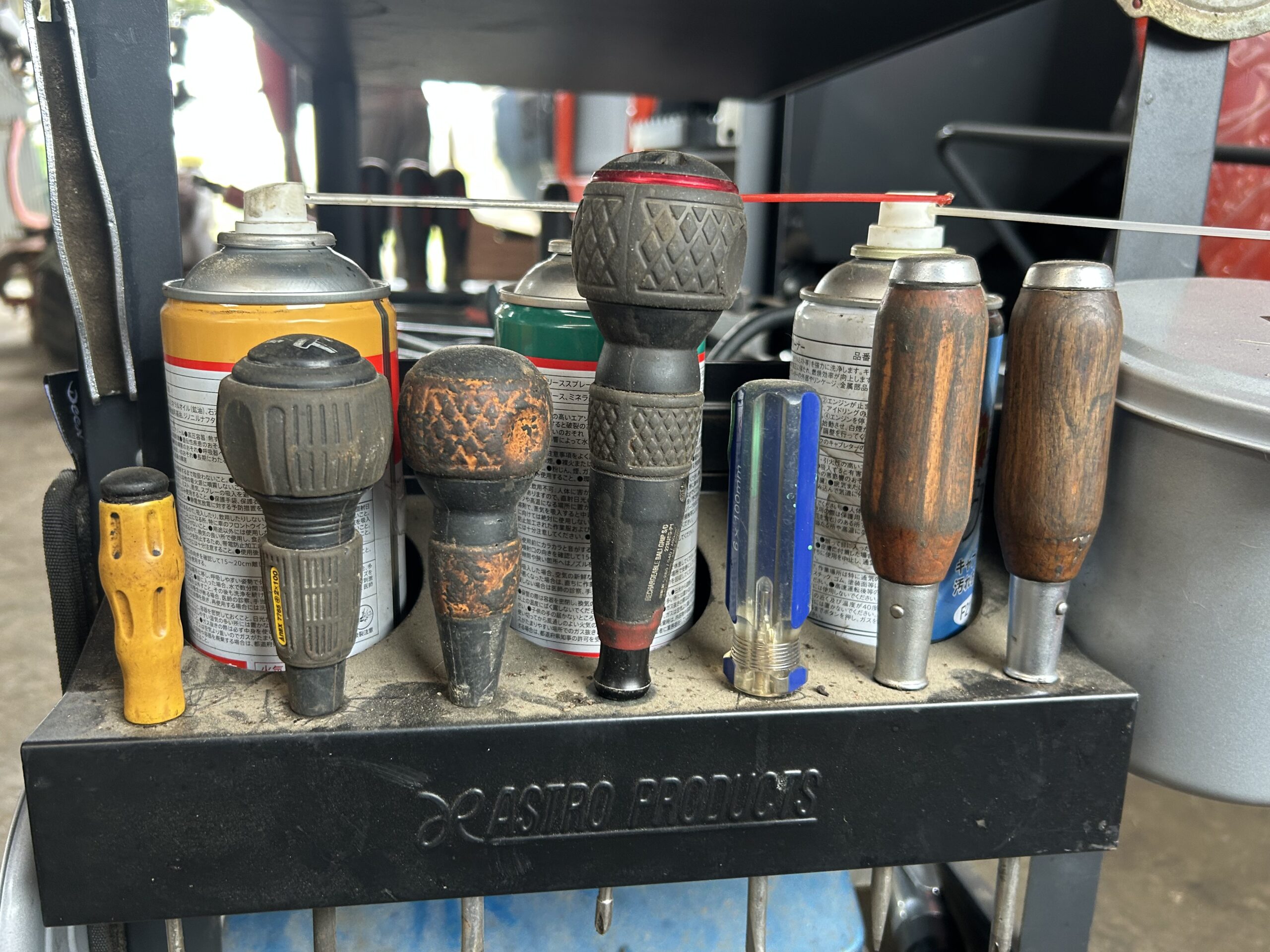 使い込まれたドライバーやハンマーの柄が並ぶ工具ラック