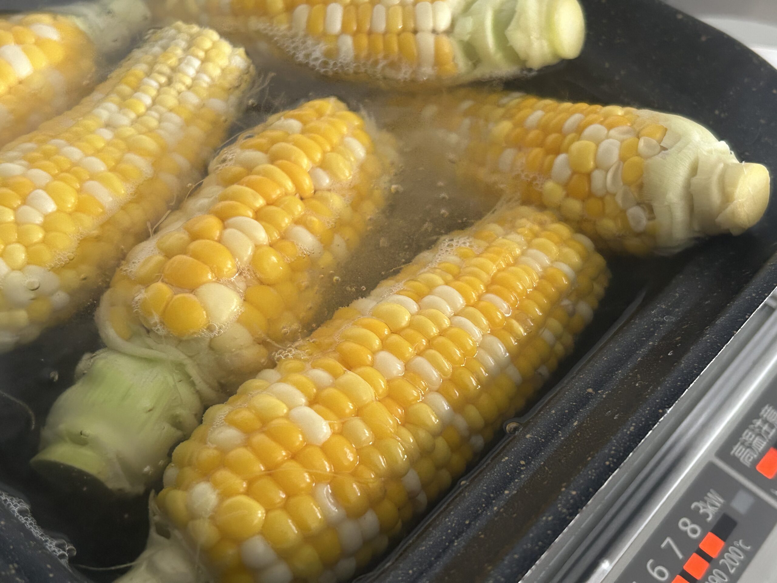 鍋で茹でている最中のとうもろこし
