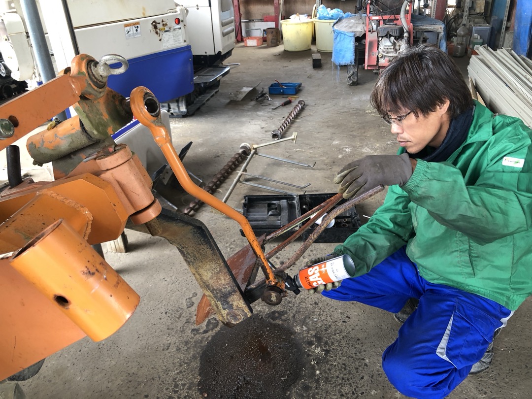 刈払機のヘッド部分を点検する整備士さん