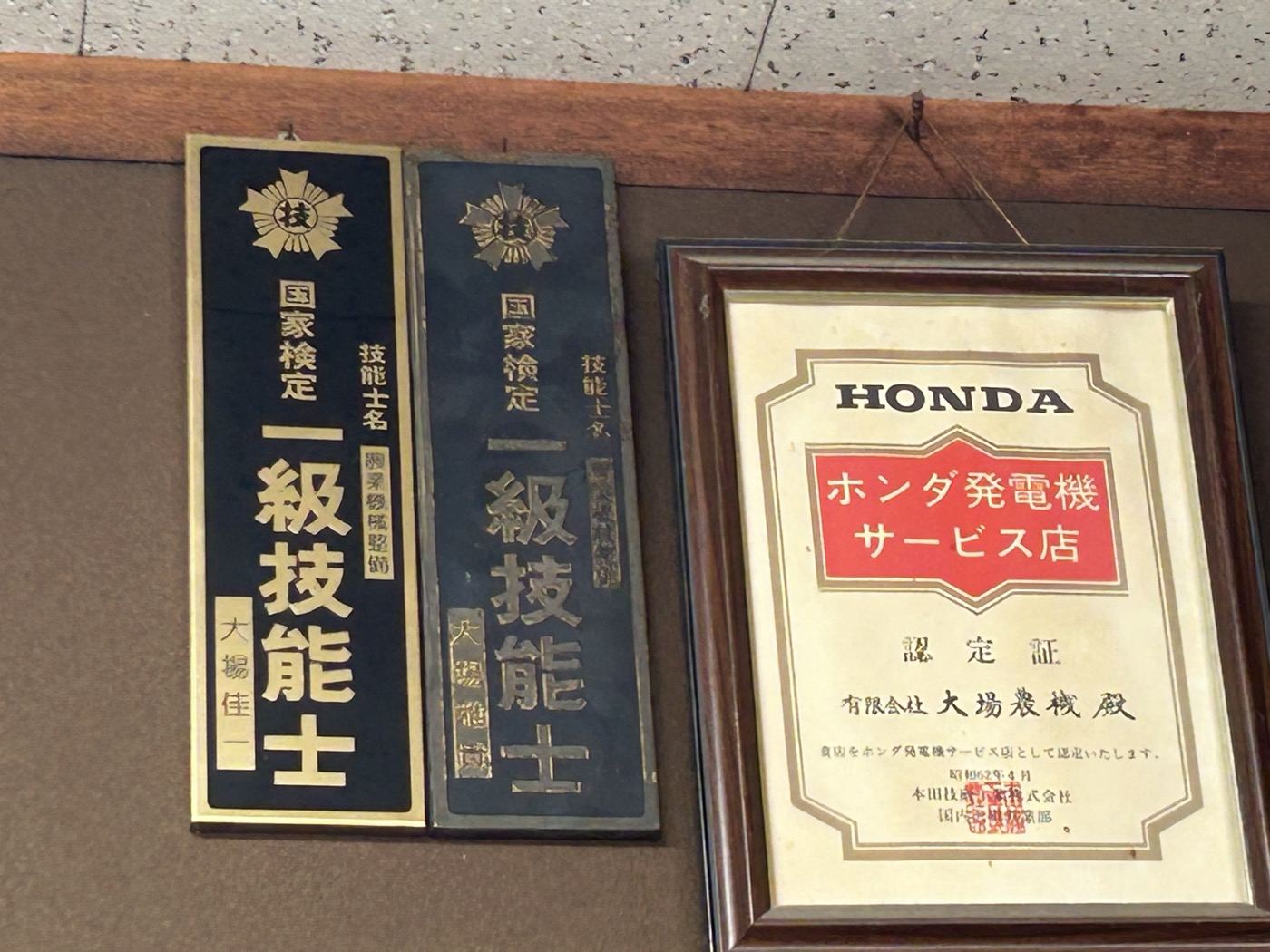 事務所に飾られている一級技能士の認定証とHONDA発電機サービス店の認定証