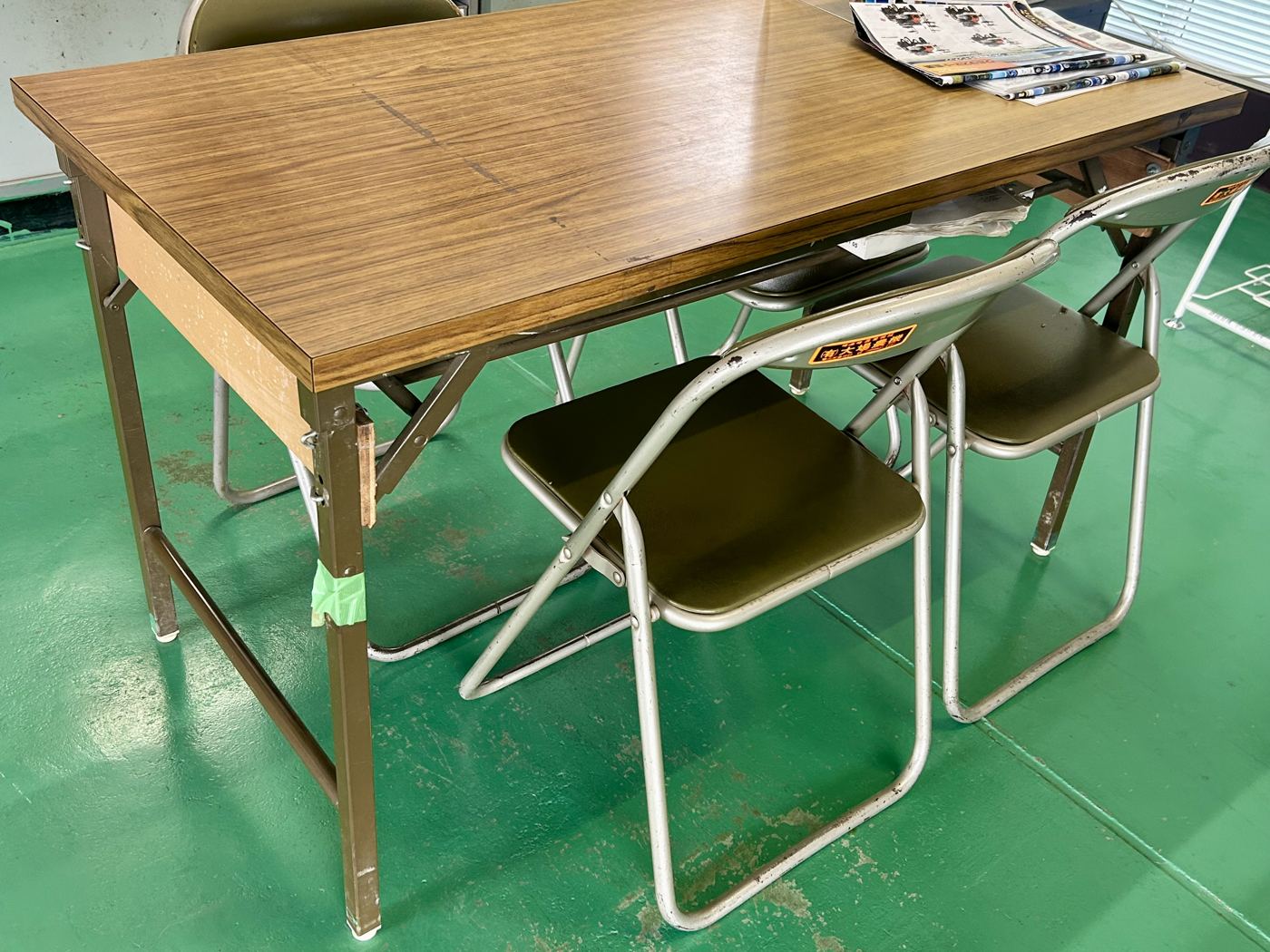30年ほど使われてきた古い木目調の机と折りたたみ椅子のセット