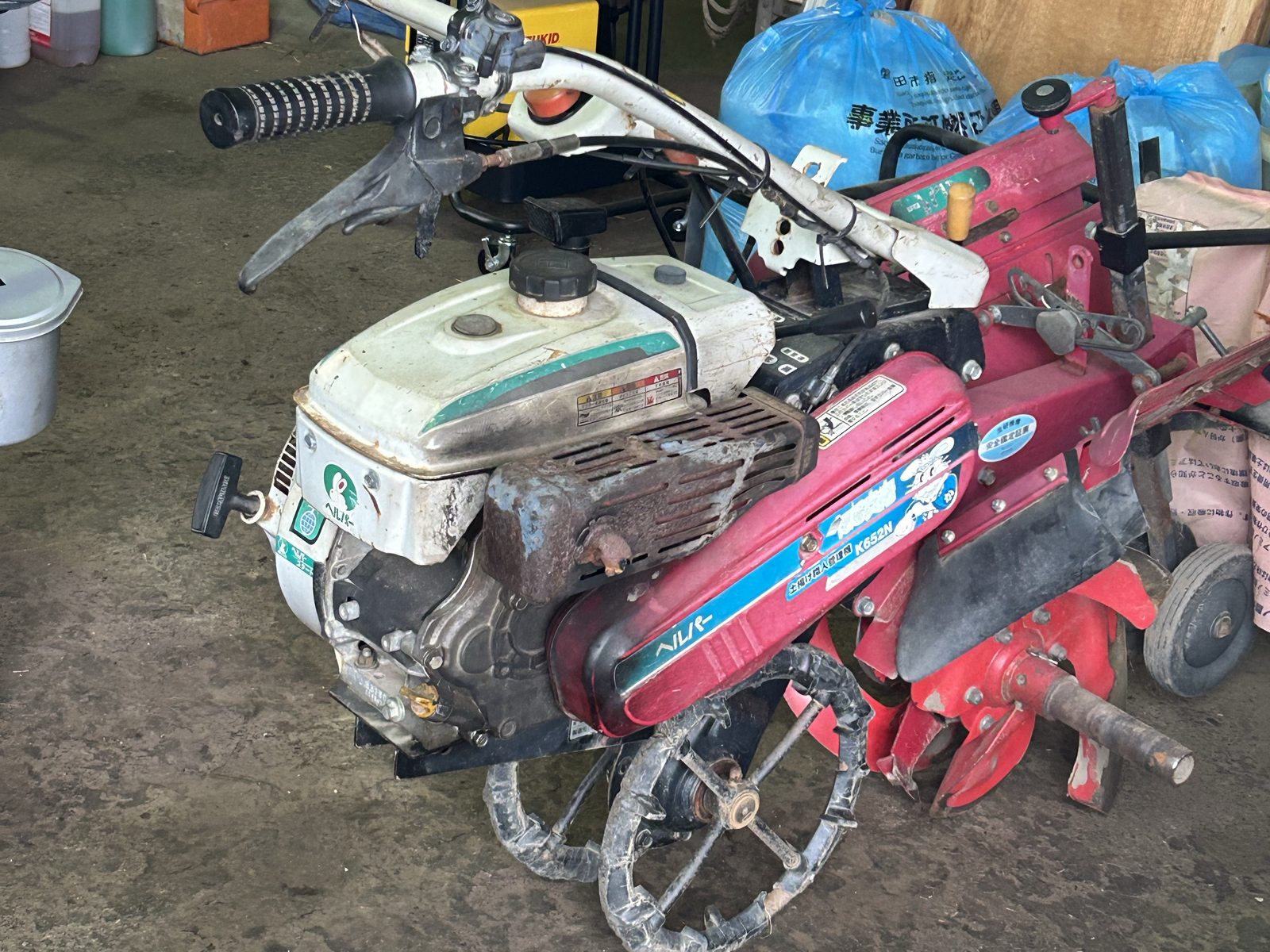作業場に置かれたホンダの管理機、鉄車輪と赤いロータリーが付いている